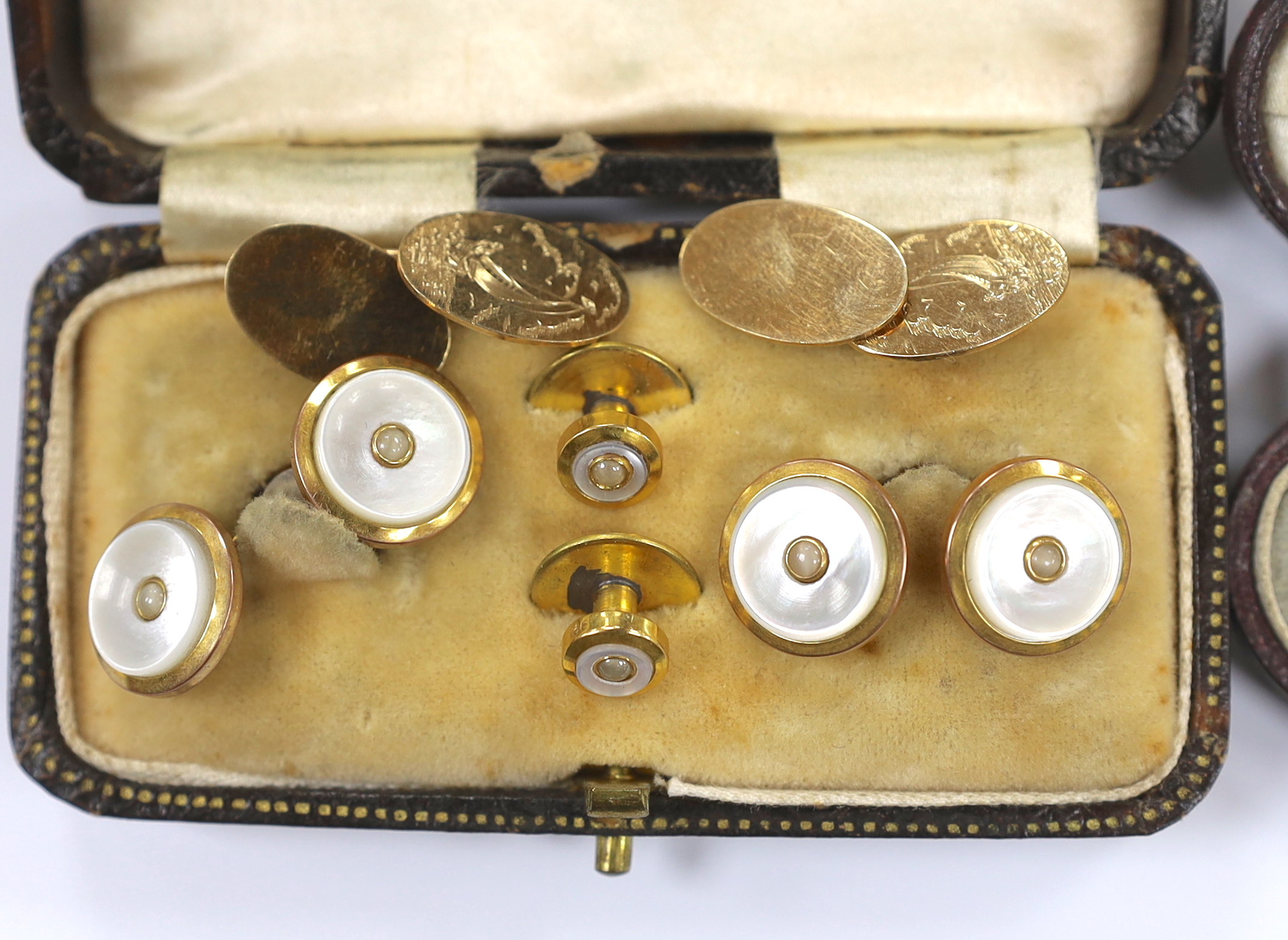 A pair of 9ct gold oval cufflinks, each engraved with a yacht, 5.8 grams, together with two yellow metal part dress stud sets.